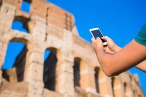 Hand holding phone by the Colosseum, Rome photo