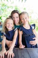 madre posando con hijas foto