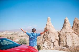 hombre de viaje con un rojo coche foto