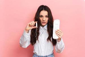 Studio shot of a young girl holding a Panty liner and tampons for menstruation. photo