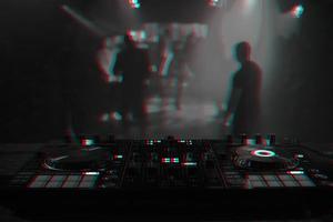 DJ consola para mezcla música con borroso personas bailando a un Club nocturno fiesta. negro y blanco con 3d falla virtual realidad efecto foto