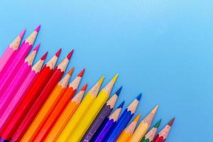 Collor wooden pencils in row isolated on bluebackground. Top view with copy space. photo