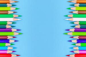 Collor wooden pencils in row isolated on bluebackground. Top view with copy space. photo