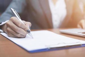 cerca arriba mano de mujer participación bolígrafo pensando y escritura datos o negocio planificación en papel para recuerda y aprender, escribir educación concepto foto