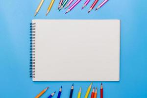 Collor wooden pencils in row isolated on bluebackground. Top view with copy space. photo