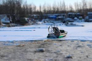 airboat in motion on ice in winter back view photo