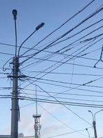 pole with many electric wires in the city sky photo