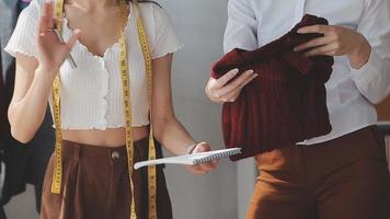 Diverse female fashion designers at work with tailor centimeters on necks and holds tablet and notepad. independent creative design business. video