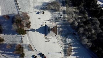 Aerial top down view of a snowy belfry in Beskydy mountain video