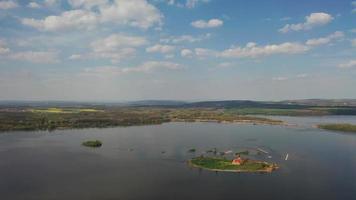 aerial backwards view of St. Linhart church on island in lake video