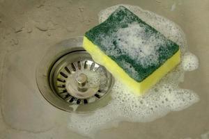 sponge with foam in kitchen sink photo