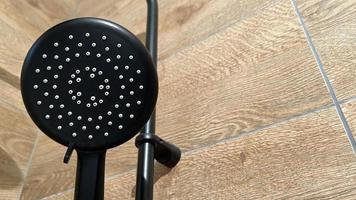 Shower black on a wooden background. Bathroom plumbing. photo