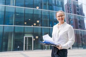 Portrait business woman with business papers, folder with files, woman looking photo