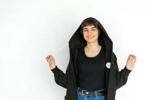 Young woman with black short hair posing in studio. Dressed in a black photo