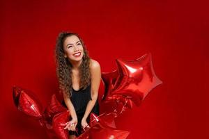 Candid content portrait girl holding lot red balloons in form stars enjoy photo