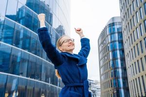 negocio éxito celebrando negocio mujer con elevado manos arriba gesto foto