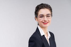 Stylish young business woman in black suit looks confidently into camera. photo