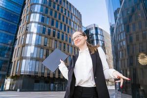 Portrait of successful business woman in stylish suit using laptop posing next photo