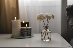 Home aroma fragrance diffuser and burning candles on bedside table in the bedroom. Interior elements photo