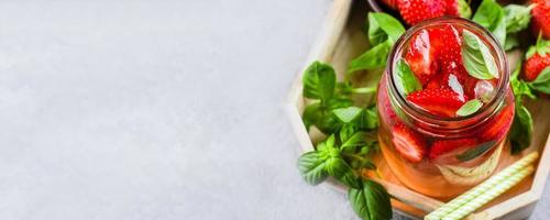 Summer Food and Drink. Lemonade with Strawberry and Basil in mason jar on wooden tray on table photo