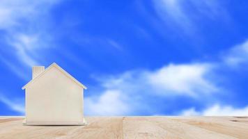 Small home model on wooden table with blue sky background.Family life and Business real estate concept. photo