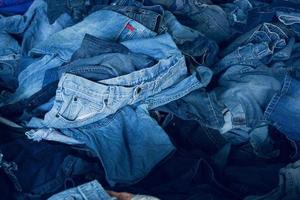 Stack of various shades blue jeans. Pile Blue denim jeans texture banner. Canvas denim fashion texture photo