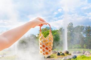 women hold basket weave boiled egg in hot spring at San Kamphaeng Hot Springs in Chiang Mai, Northern Thailand photo