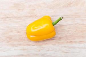 yellow ripe peppers lies on wooden cutting board photo