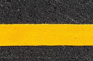 Yellow line on new asphalt detail,Street with yellow line texture photo