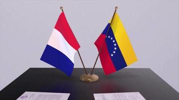 Venezuela y Francia nacional banderas en mesa en diplomático conferencia habitación. política acuerdo acuerdo video