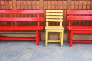 Red and Yellow wooden bench chairs in the park. photo