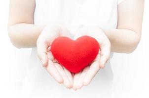 Woman holding and protecting give a red heart shape on white background close-up,Symbol of love or dating Valentines day photo