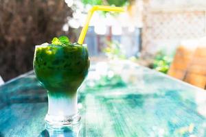 Iced green tea latte in glass on table at the garden photo