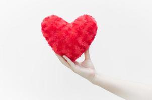 mujer sosteniendo y protegiendo una forma de corazón rojo en primer plano de fondo blanco, símbolo de amor o saliendo con el día de san valentín foto