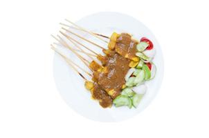 Grilled Pork Satay with Peanut Sauce and Vinegar on white dish isolated on white background photo