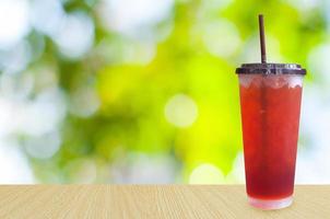 té helado sobre fondo verde de la naturaleza, bebidas de verano con hielo foto