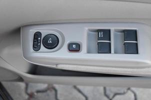 car interior details of door handle with windows controls and adjustments. Car window controls photo