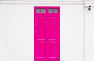 traditional Pink door wooden of an old on white wall,in Thailand photo