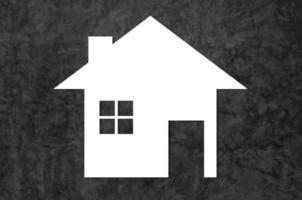 blanco casa icono en oscuro cemento antecedentes como símbolo de hipoteca, sueño casa en naturaleza antecedentes foto