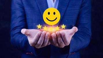 cliente servicios mejor excelente negocio clasificación experiencia, positivo revisión y comentario, satisfacción encuesta concepto. mano de un empresario espectáculo contento sonrisa cara con cinco estrella. foto