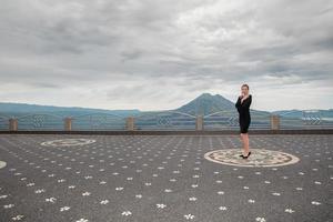 Lovely woman wearing in black dress against the backdrop of the volcano Batur photo