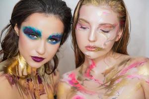 Two pretty young women with creative make-up photo