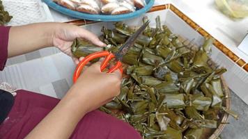 ordenado arriba tradicional indonesio tradicional mercado aperitivos, nagasari por corte fuera irregular hojas a hacer eso Mira atractivo video