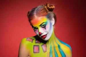 Cute young woman with a aqua makeup clown photo