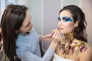 The artist applies makeup to a nice young model photo