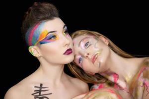 Two attractive young women with creative make-up photo