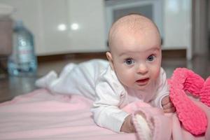 encantador pequeño bebé mentiras en un rosado tartán foto