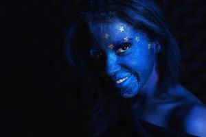 Young cute girl with blue face painting photo