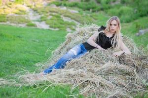 Beautiful woman posing sitting on the hay photo