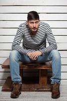 Nice man sits on a wooden table photo